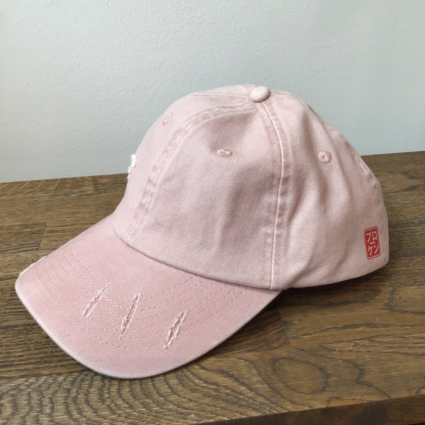 Pink cap on a wooden surface with a light gray background